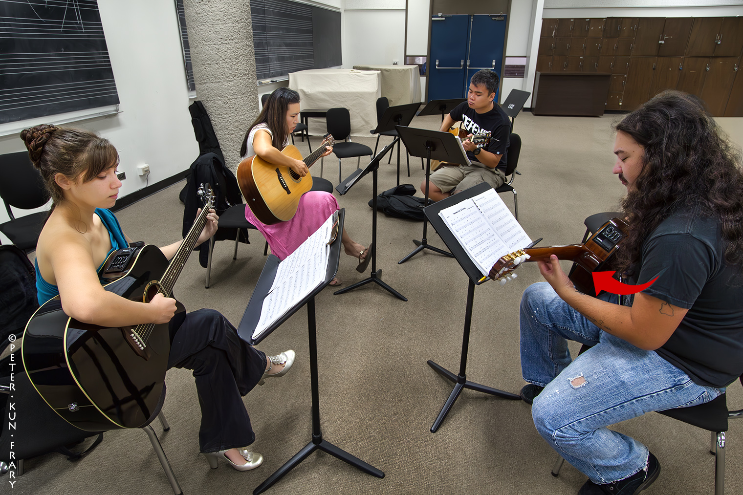 Casual Players | The player on the right shifts the guitar's neck away from his body to enhance fingerboard access.